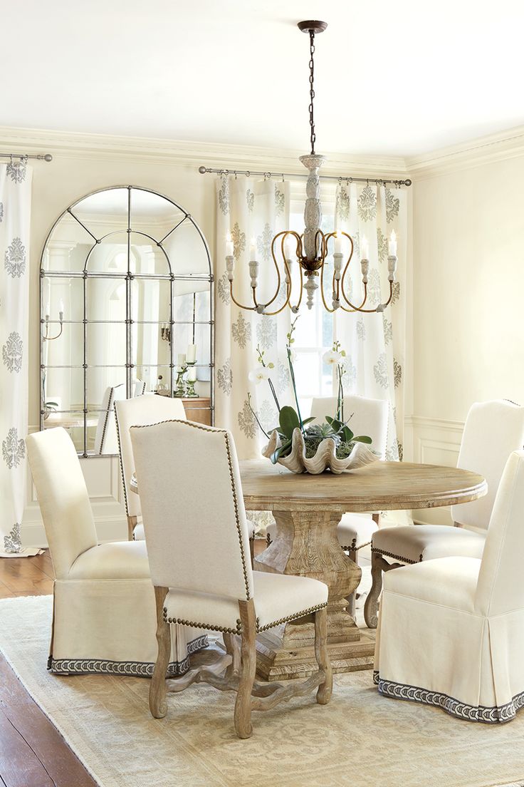 hình ảnh phòng ăn phong cách Rustic sang trọng với đèn chùm cổ điển, ghế ngồi bọc nệm trắng, cửa sổ vòm