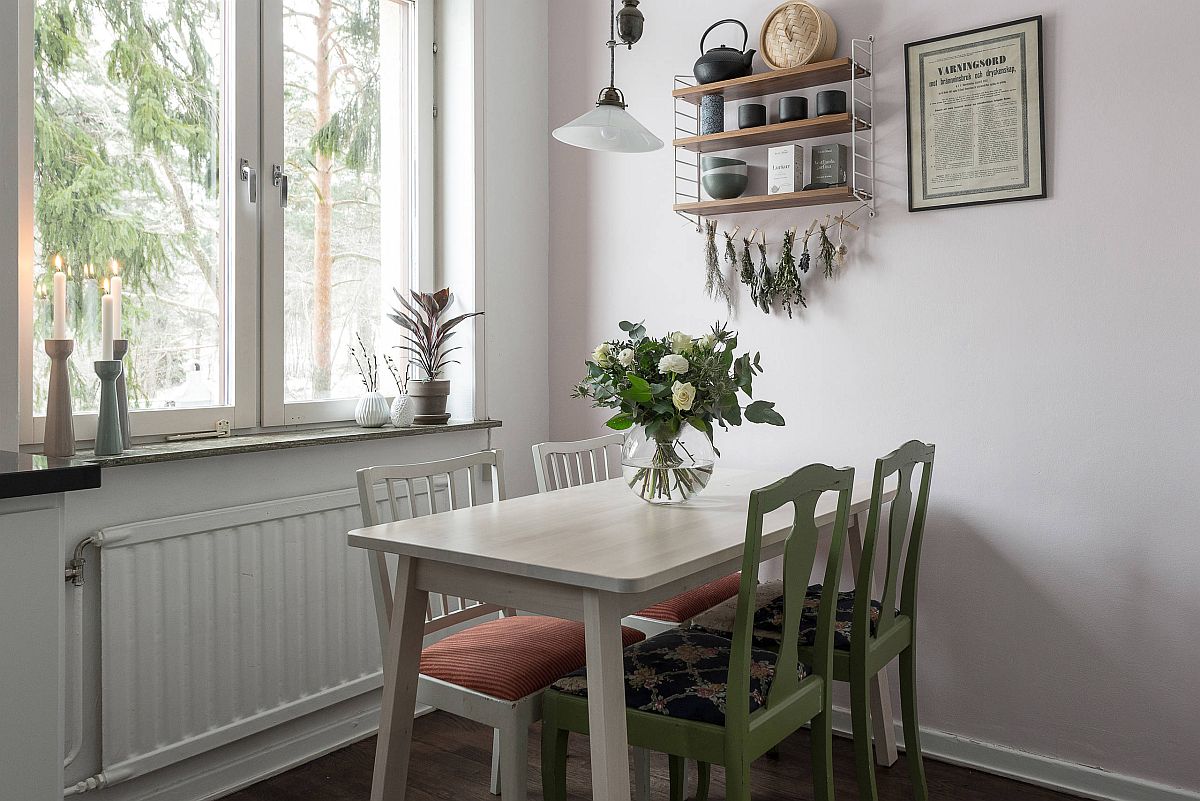 hình ảnh phòng ăn nhỏ cạnh cửa sổ kính thoáng sáng, ghế ngồi sơn màu xanh lá, lọ hoa trang trí